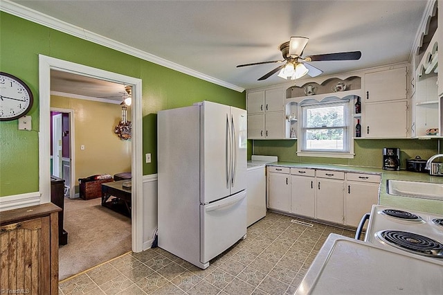 kitchen with sink, white appliances, ornamental molding, and white cabinets