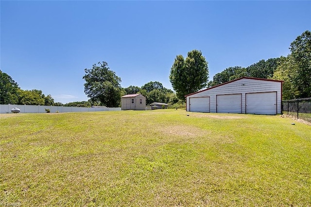 view of yard with a garage and an outbuilding