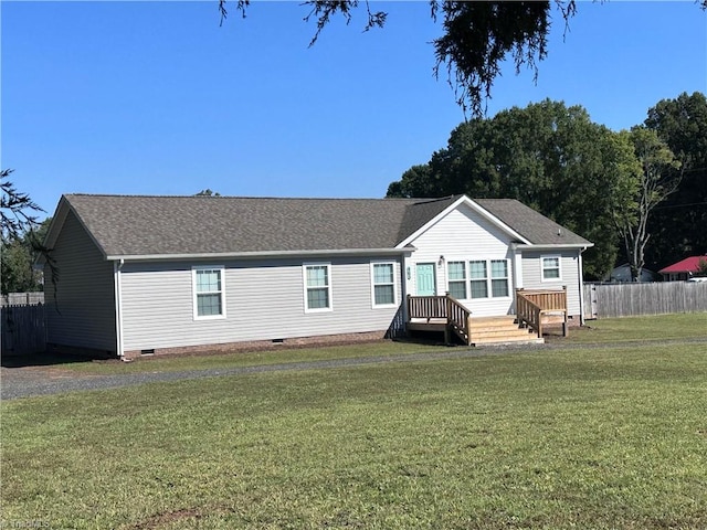 rear view of house featuring a lawn and a deck