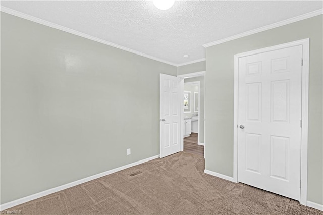 unfurnished bedroom featuring carpet floors, ornamental molding, and a textured ceiling