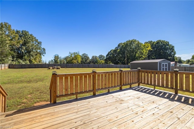 wooden terrace with a storage shed and a lawn