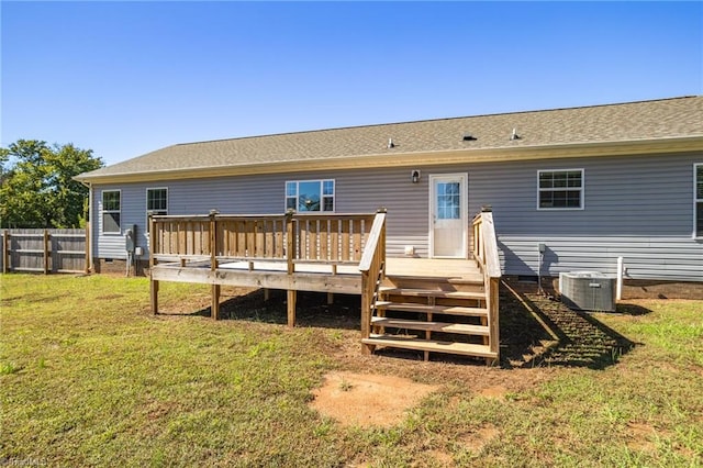 rear view of property featuring central AC, a yard, and a wooden deck