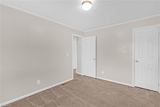 carpeted spare room with crown molding and a textured ceiling