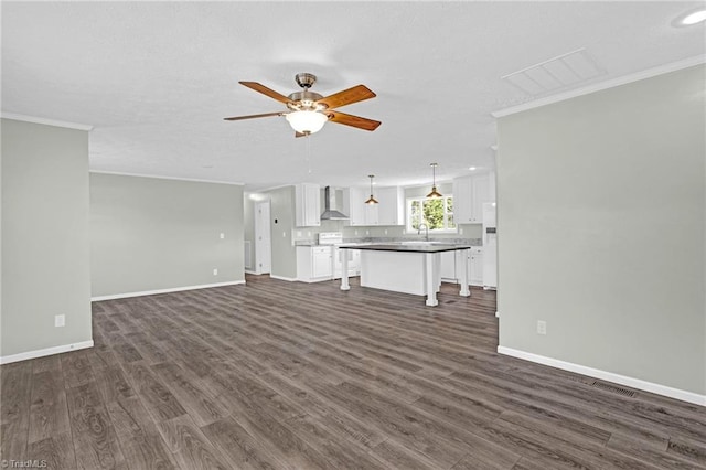 unfurnished living room featuring ornamental molding, ceiling fan, dark wood-type flooring, and sink