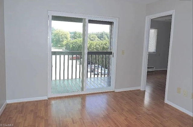 doorway to outside featuring wood-type flooring and baseboard heating