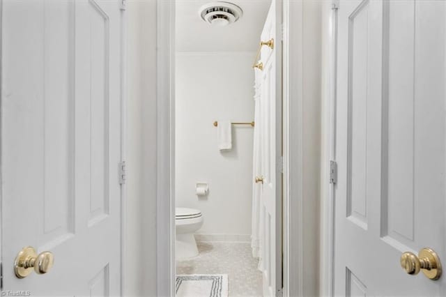 bathroom featuring toilet and tile patterned flooring