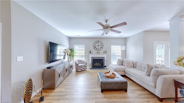 living room featuring ceiling fan, a wealth of natural light, and light wood-type flooring