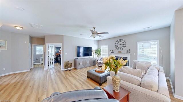 living room with ceiling fan and light wood-type flooring