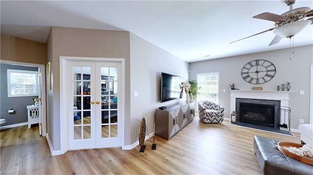 living room with light hardwood / wood-style floors, french doors, and ceiling fan