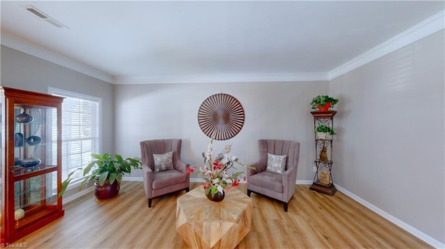 living area with light hardwood / wood-style floors and ornamental molding