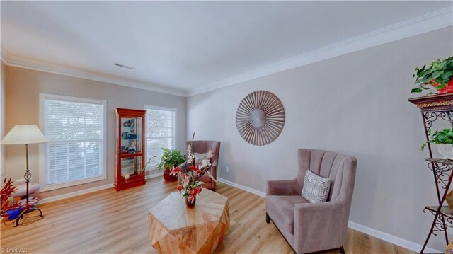 living area with light wood-type flooring and crown molding