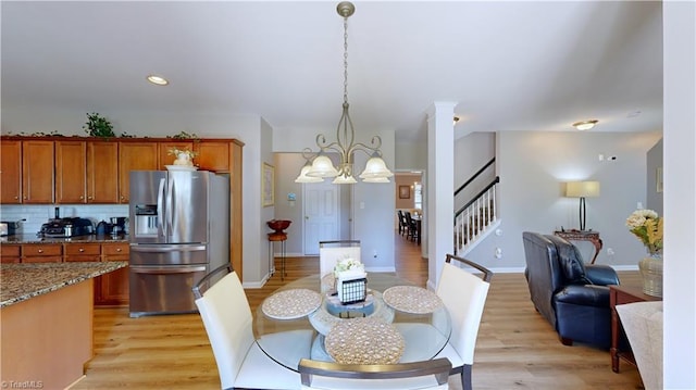 dining space with an inviting chandelier, stairway, recessed lighting, and light wood finished floors