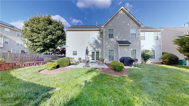 rear view of house featuring a lawn, a patio, and fence