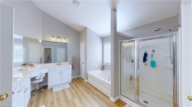 full bath featuring plenty of natural light, a shower stall, lofted ceiling, and a sink