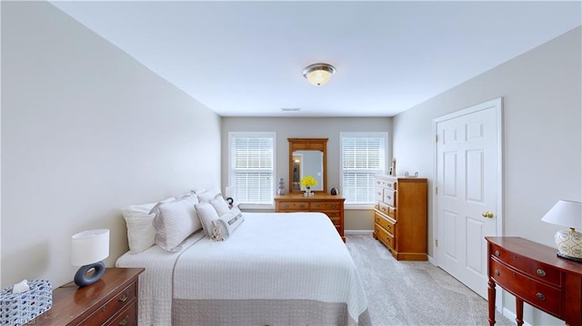 bedroom featuring light colored carpet and baseboards