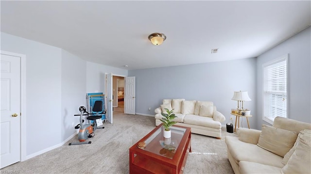 carpeted living area featuring visible vents and baseboards