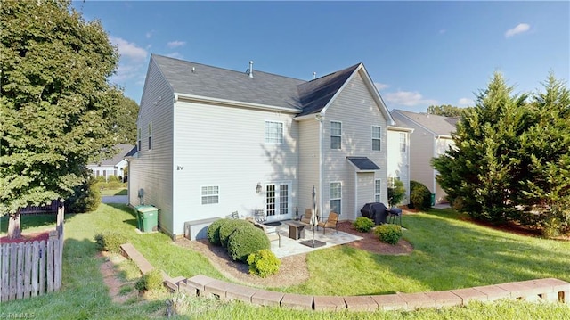 rear view of property featuring fence, a patio area, and a lawn