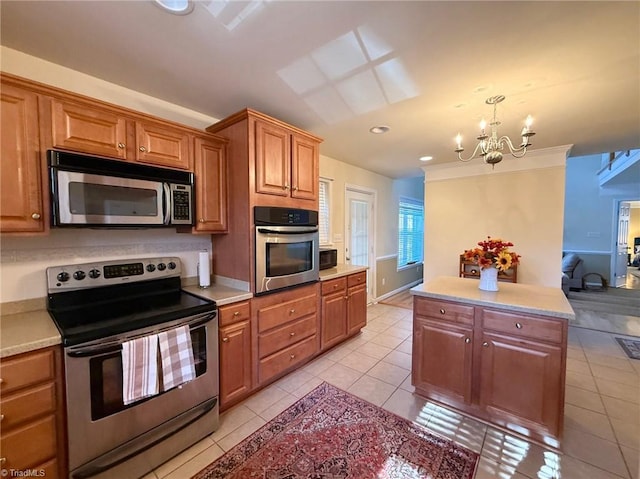 kitchen featuring stainless steel appliances, decorative light fixtures, a chandelier, and light tile patterned floors