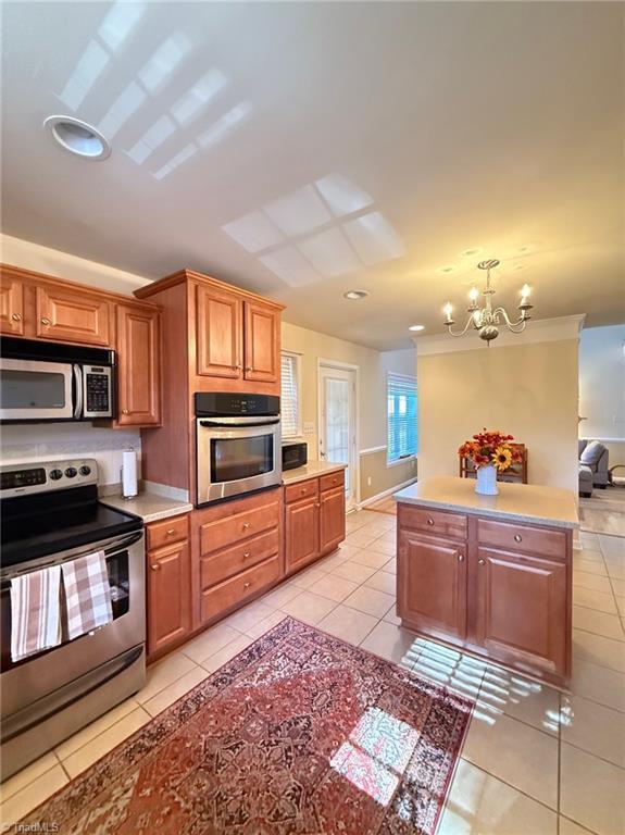 kitchen featuring stainless steel appliances, an inviting chandelier, and light tile patterned flooring