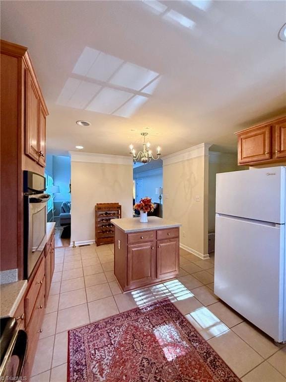 kitchen featuring light tile patterned floors, oven, a kitchen island, an inviting chandelier, and white refrigerator