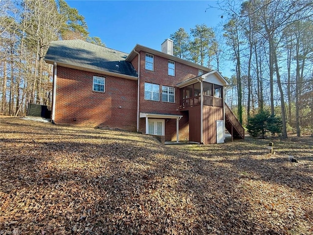 rear view of property featuring a sunroom