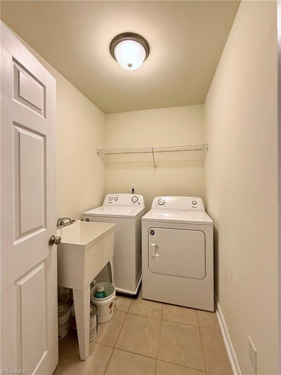 laundry area featuring separate washer and dryer and light tile patterned floors