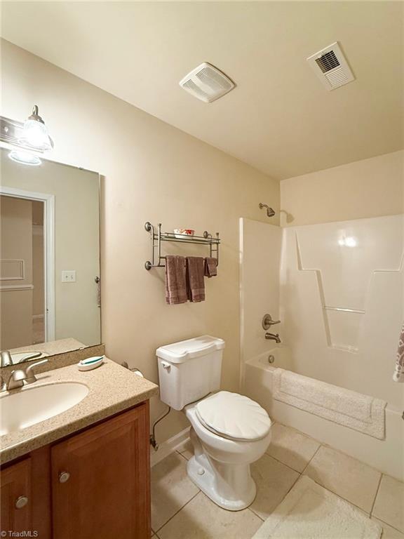 full bathroom featuring toilet, tile patterned floors, bathing tub / shower combination, and vanity