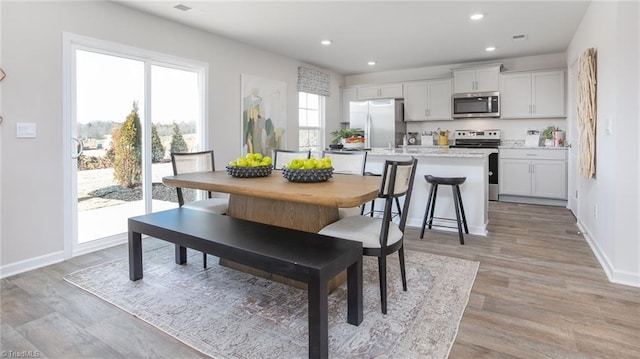 dining space featuring recessed lighting, baseboards, and light wood-style flooring