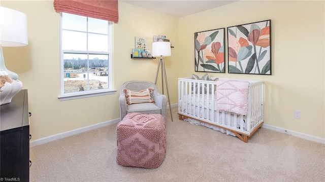 carpeted bedroom with baseboards and a crib