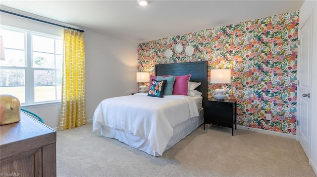 bedroom featuring light colored carpet, baseboards, multiple windows, and wallpapered walls