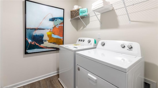 washroom featuring laundry area, dark wood finished floors, washing machine and dryer, and baseboards
