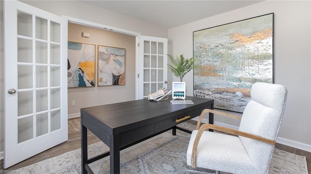 office space featuring baseboards, french doors, and wood finished floors