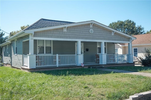 bungalow-style house featuring a porch, a front yard, and a shingled roof
