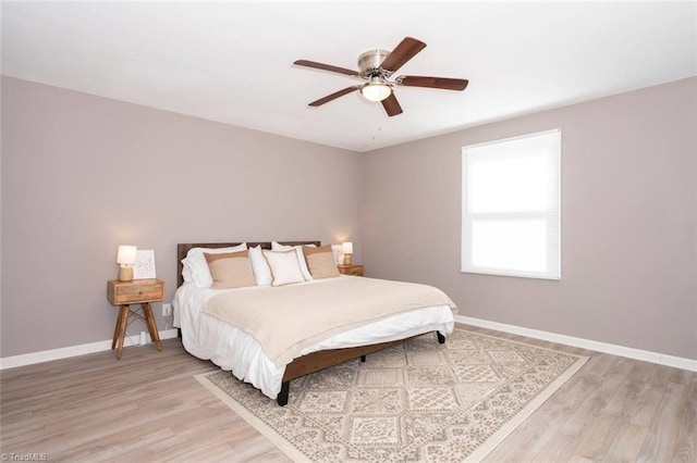 bedroom featuring light wood-type flooring, baseboards, and ceiling fan