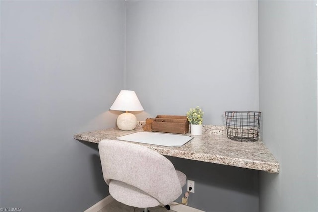 home office with built in desk and baseboards