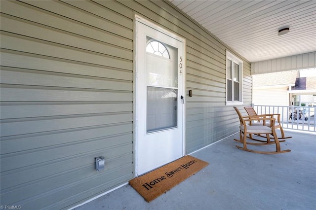 view of exterior entry featuring covered porch