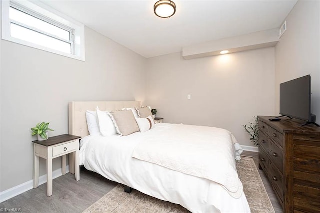 bedroom featuring wood finished floors and baseboards