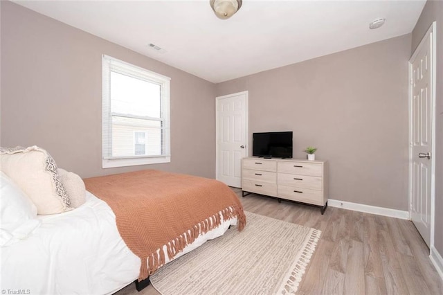 bedroom featuring light wood-style floors and baseboards