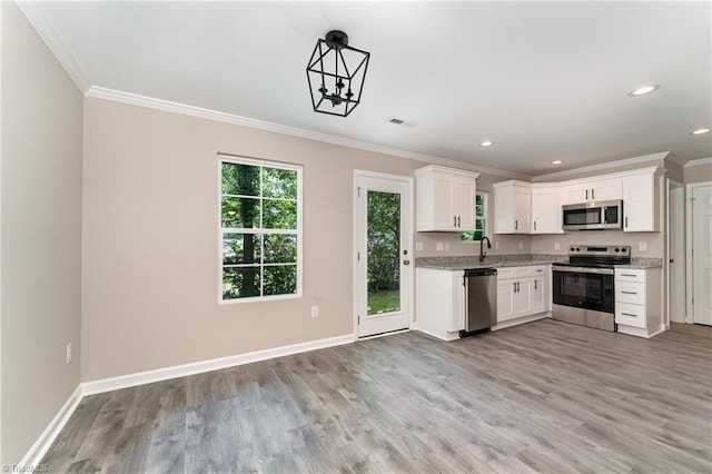 512 Guilford Ave, High Point, NC 27262 - kitchen with stainless steel appliances, ornamental molding, light wood-style flooring, baseboards, and white cabinets