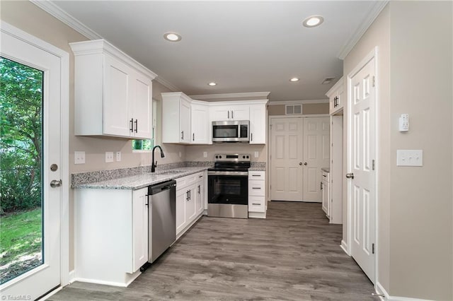512 Guilford Ave, High Point, NC 27262 - kitchen with appliances with stainless steel finishes, plenty of natural light, light stone counters, ornamental molding, and white cabinets