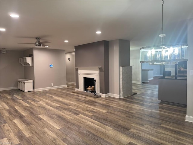 unfurnished living room featuring dark wood-type flooring and ceiling fan