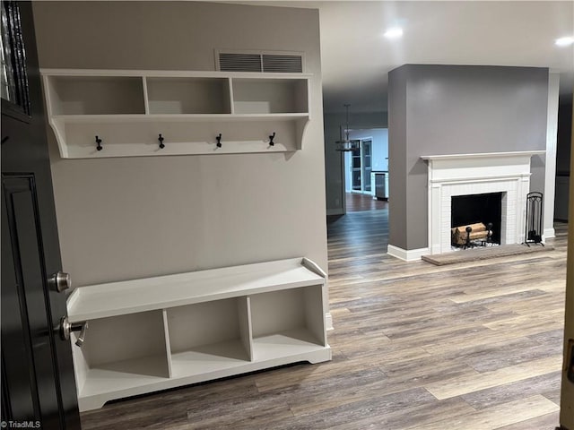 mudroom with hardwood / wood-style floors and a fireplace