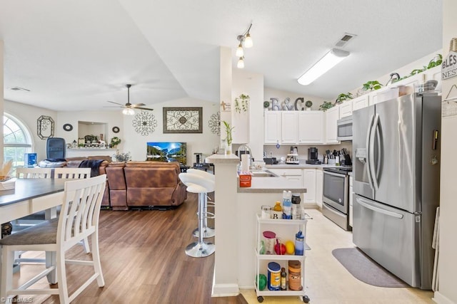 6112 Hedgecock Cir Unit 3B, High Point, NC 27265 - kitchen featuring appliances with stainless steel finishes, lofted ceiling, a peninsula, open floor plan, and a sink