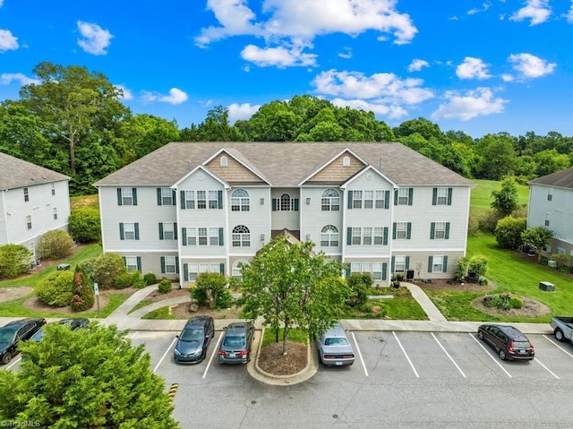 6112 Hedgecock Cir Unit 3B, High Point, NC 27265 - view of front of home featuring uncovered parking, a shingled roof, and view of scattered trees