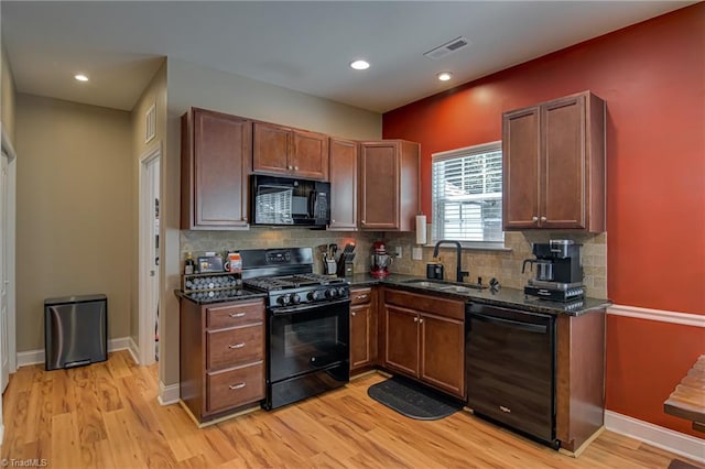 4548 River Gate Dr, Clemmons, NC 27012 - kitchen featuring black appliances, a sink, tasteful backsplash, light wood-style flooring, and dark stone countertops