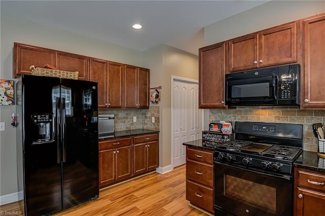 4548 River Gate Dr, Clemmons, NC 27012 - kitchen featuring black appliances, light wood-style flooring, decorative backsplash, dark stone countertops, and baseboards