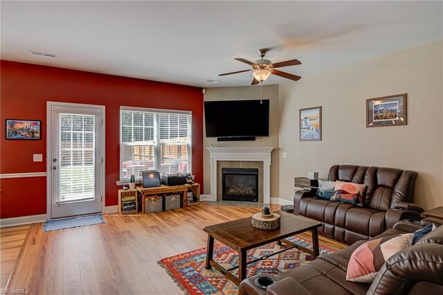 4548 River Gate Dr, Clemmons, NC 27012 - living area with ceiling fan, a tiled fireplace, light wood-style flooring, and baseboards