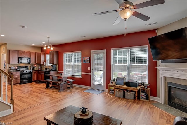 4548 River Gate Dr, Clemmons, NC 27012 - living room with light wood finished floors, a tile fireplace, baseboards, ceiling fan, and recessed lighting