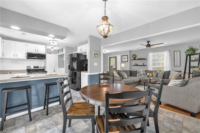6937 US Highway 158, Stokesdale, NC 27357 - dining room featuring a chandelier, stone finish flooring, and a ceiling fan