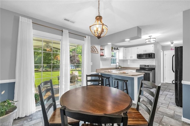 6937 US Highway 158, Stokesdale, NC 27357 - dining space featuring stone tile floors and a chandelier